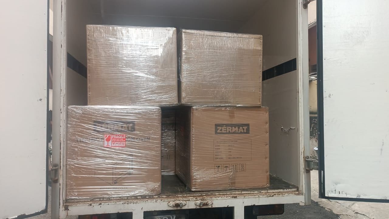Karton oven di-shrink-wrap & ditanda FRAGILE, disusun dalam lori